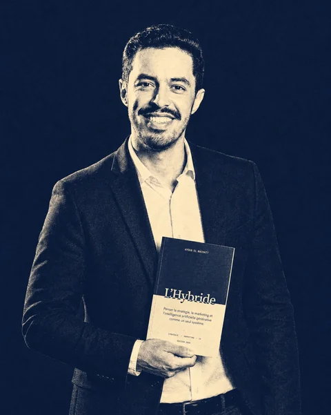 Ayoub El Machatt holding his book, L’Hybride